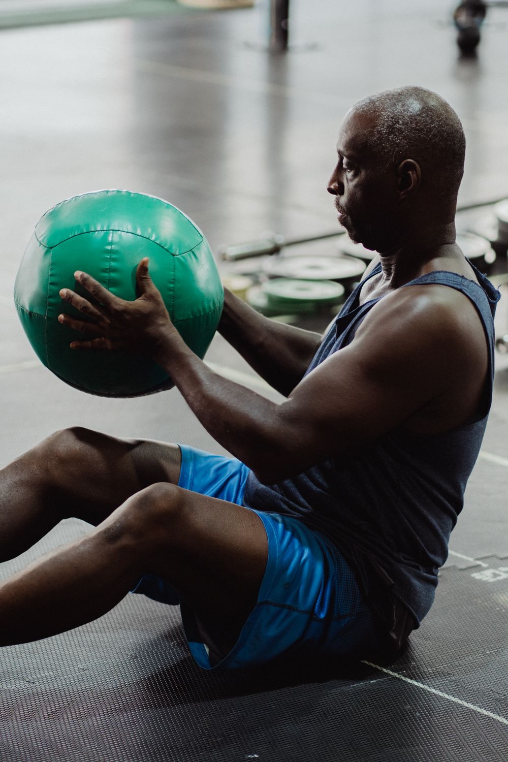 Idoso realizando exercício de equilíbrio com bola suíça para prevenção de quedas em fisioterapia domiciliar